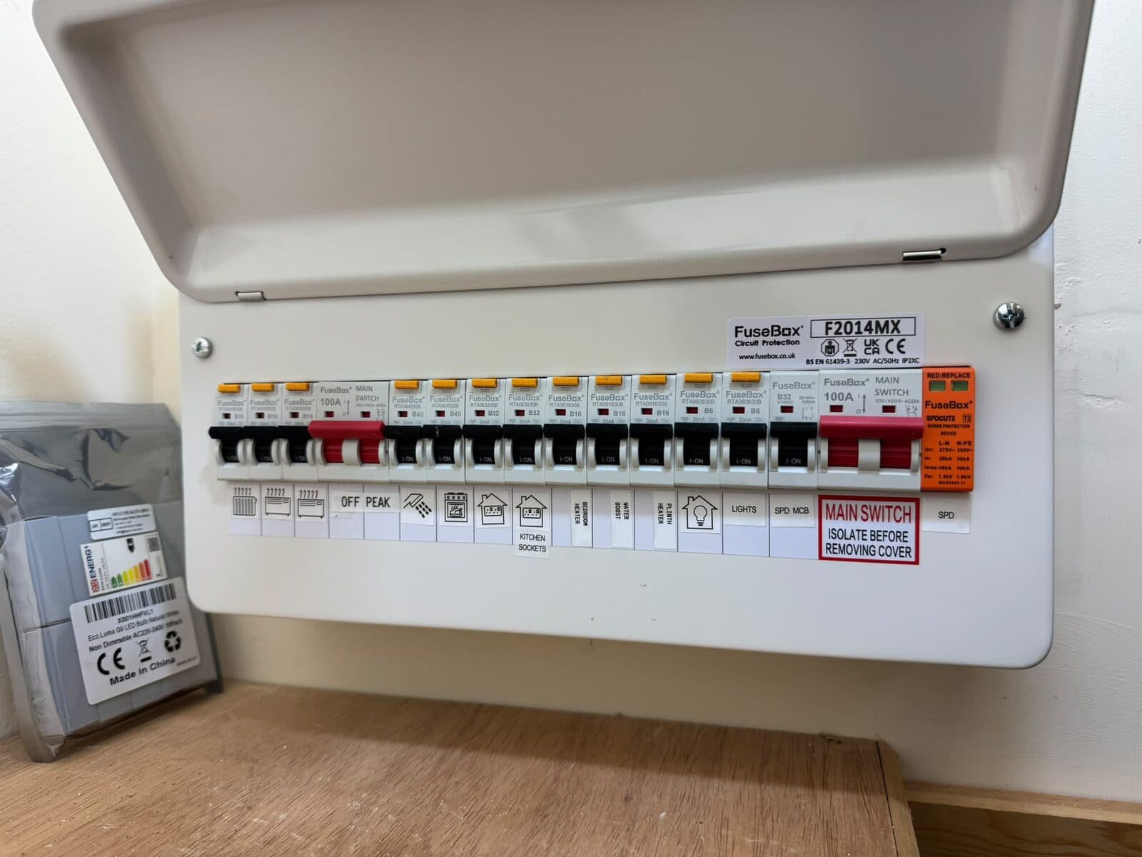 New consumer unit with every circuit labelled, cover open, beside the electric meter