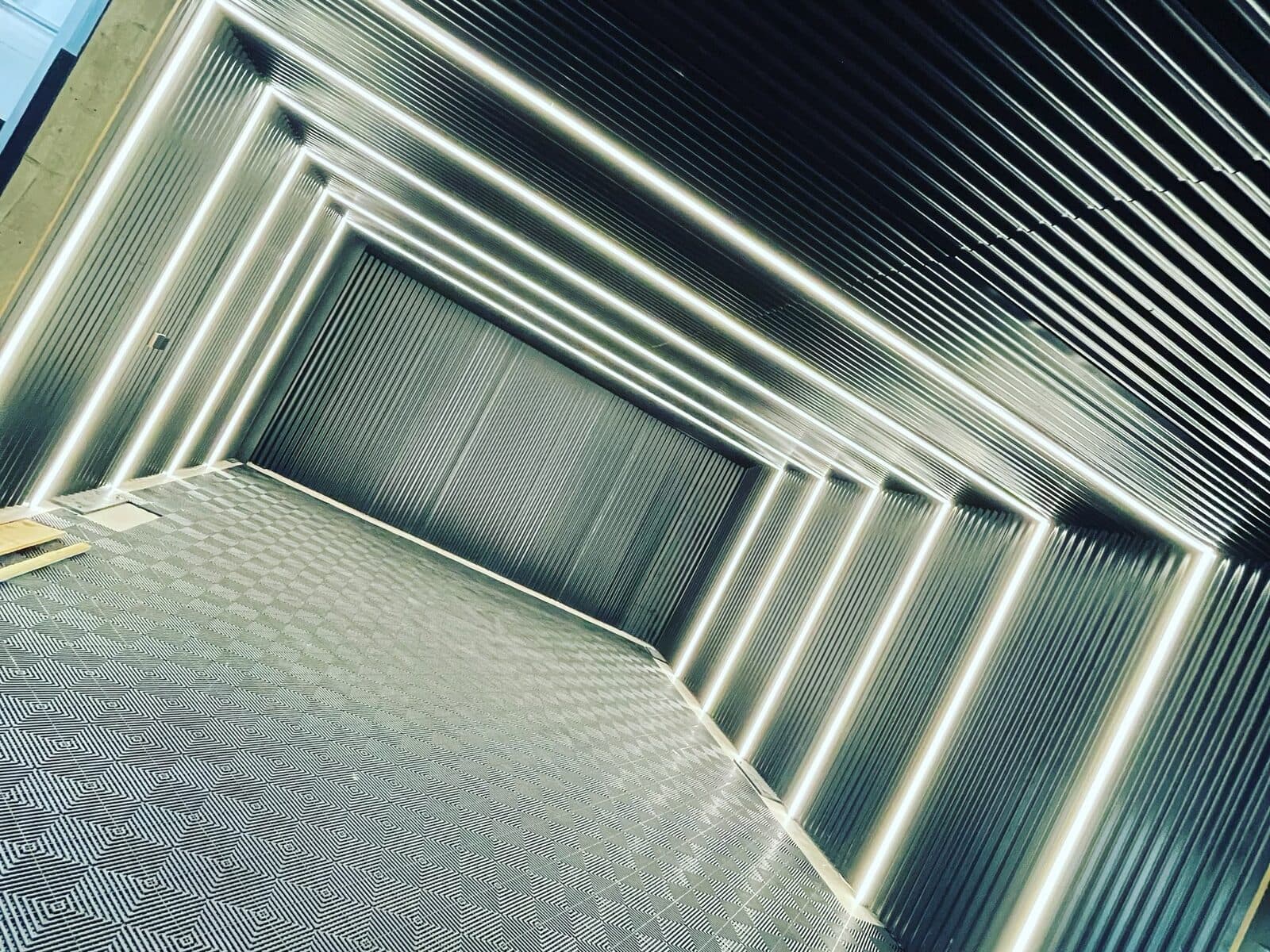 Steel-clad commercial unit lit with rows of LED strip lights framing the walls and ceiling